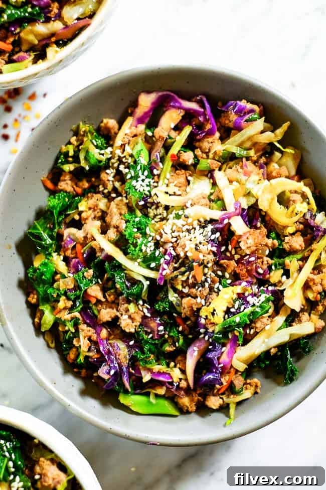 Egg roll in a bowl topped with sesame seeds. Made with cruciferous veggies, ground pork and a savory sauce. 