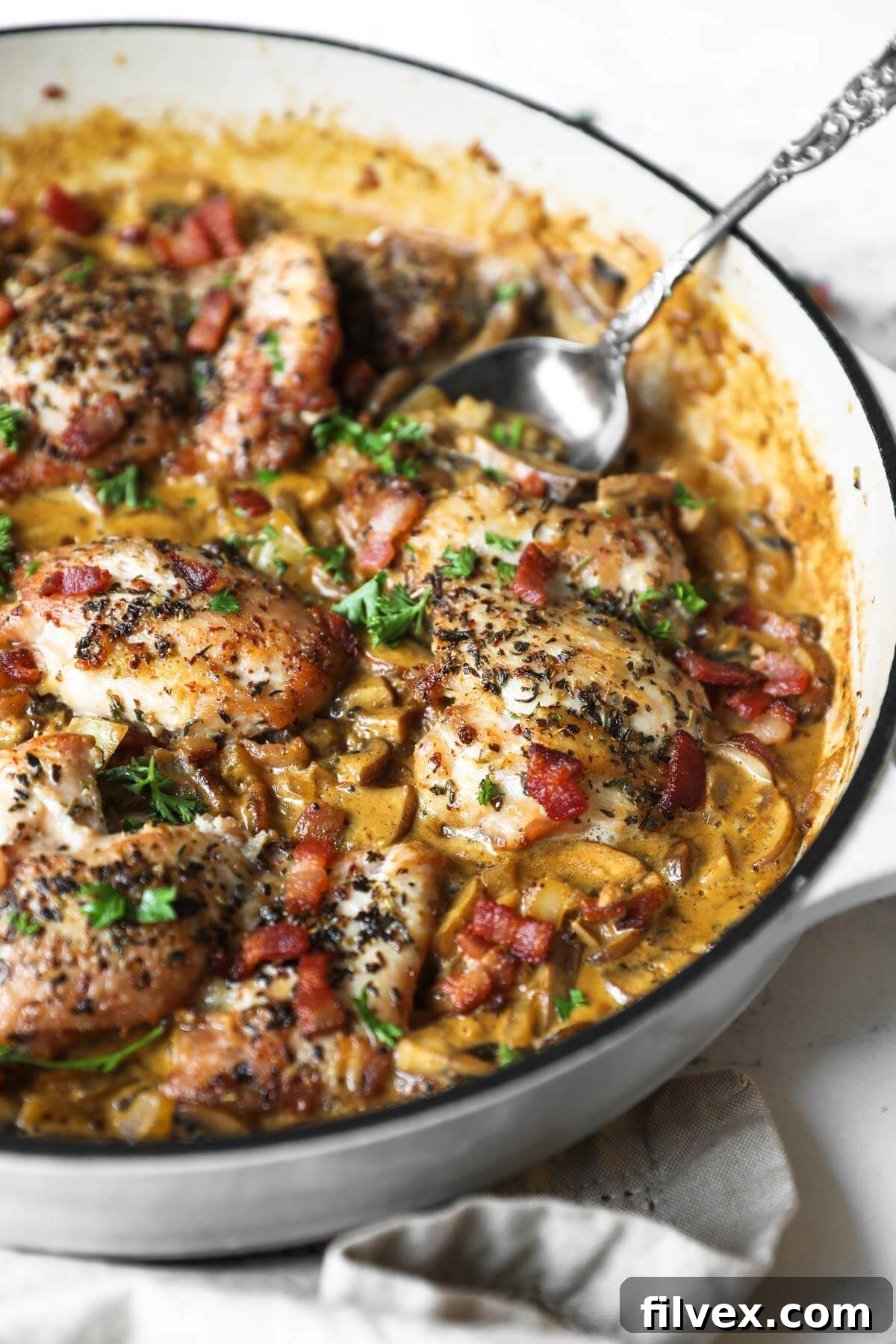 Close-up of creamy garlic chicken simmering in a skillet, showing the rich texture of the sauce and tender chicken pieces.