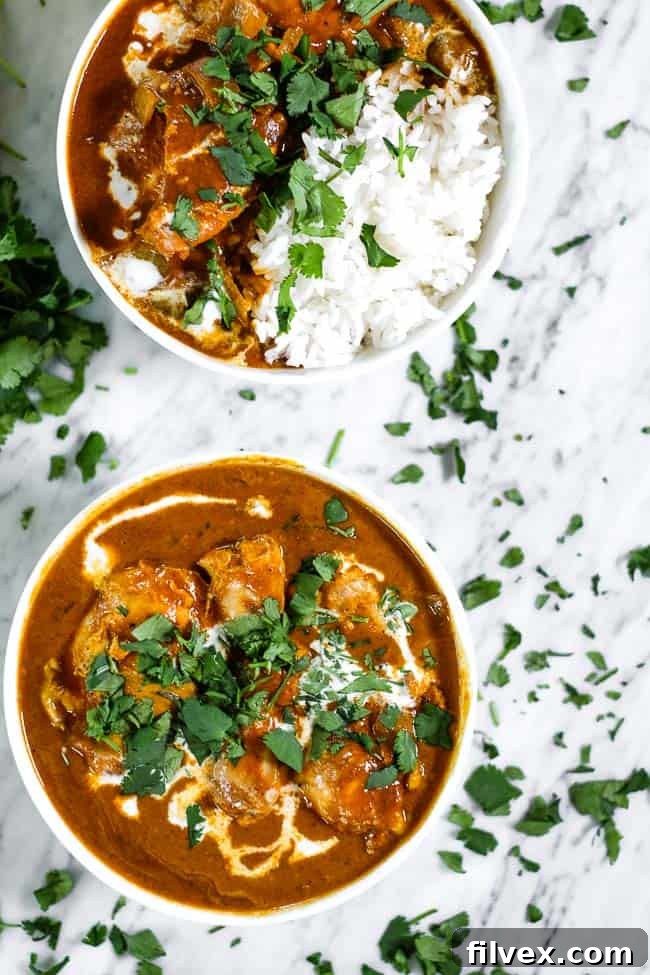 Instant pot butter chicken in two bowls one with white rice. Both bowls topped with coconut milk and chopped fresh cilantro. 