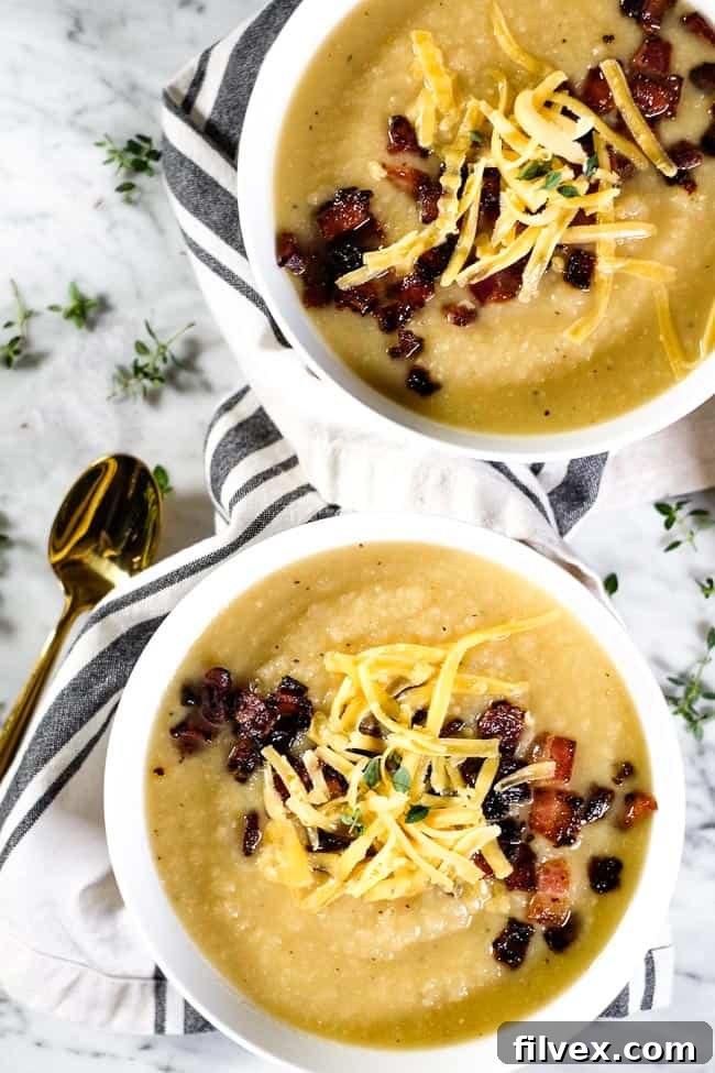 Two generous bowls of creamy celeriac soup, generously topped with crispy bacon bits, shredded cheese (optional), and fresh thyme sprigs, showcasing its inviting texture and customizable nature.