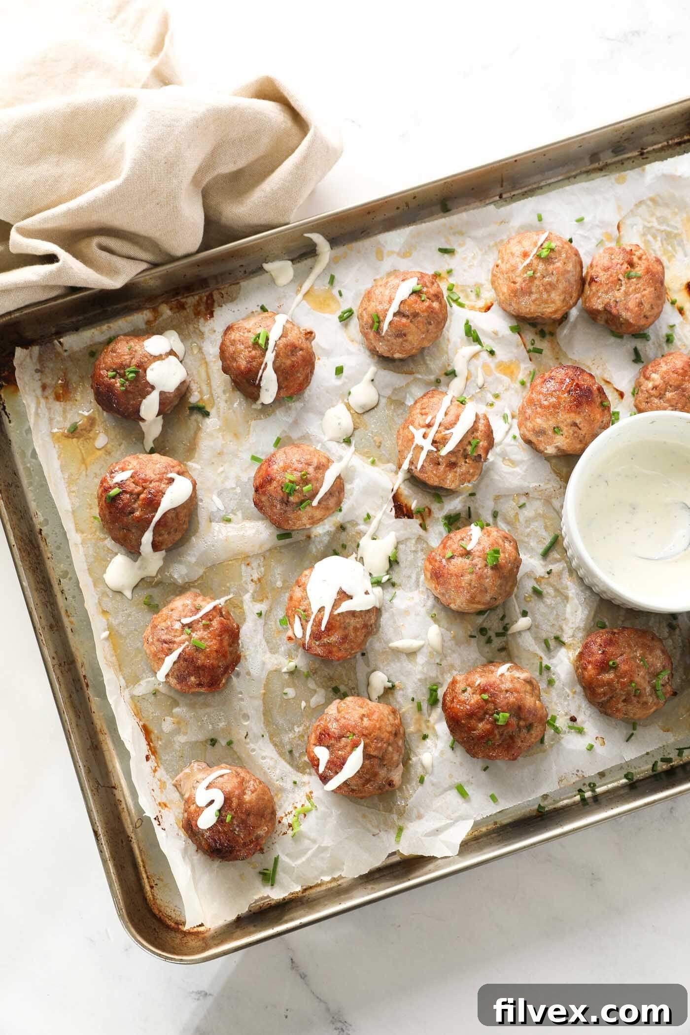 Baked pork meatballs topped with fresh herbs, ready to be served
