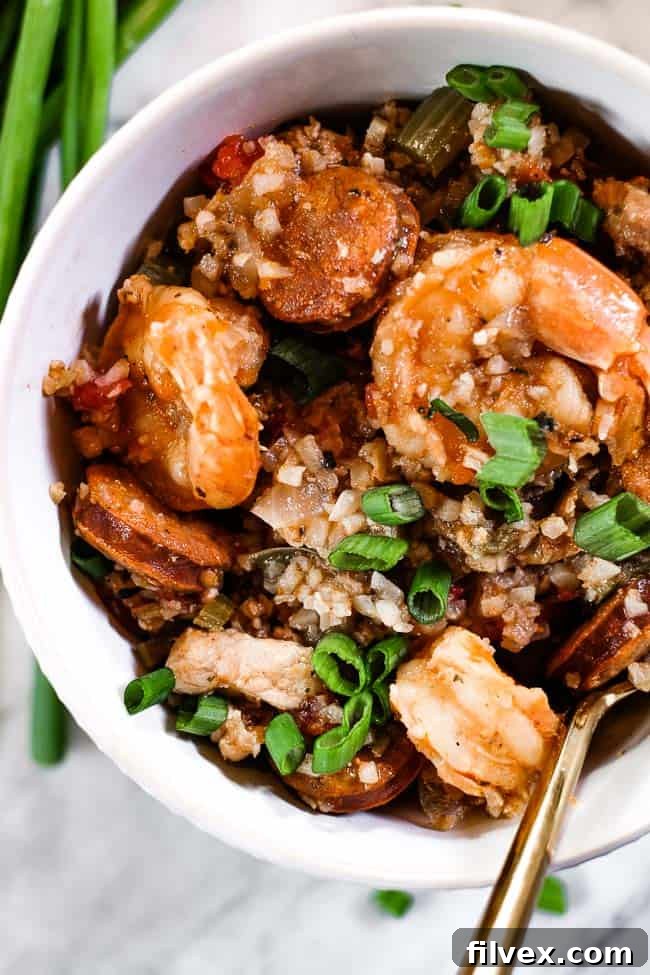 A close-up view of Instant Pot Jambalaya in a bowl, garnished with fresh green onions, showcasing its rich texture and enticing colors.