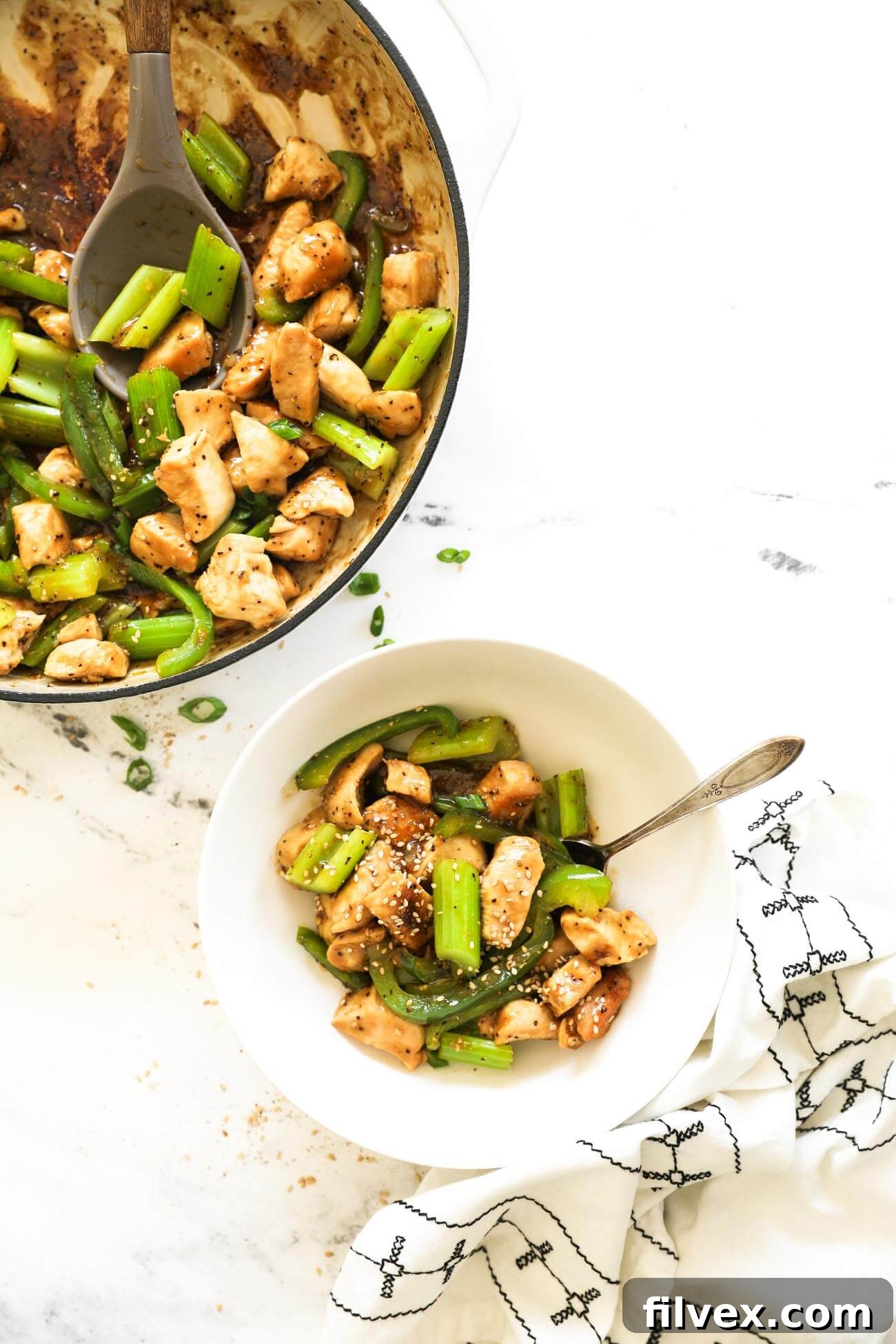 Close-up of black pepper chicken stir-fry with bell peppers and celery in a pan