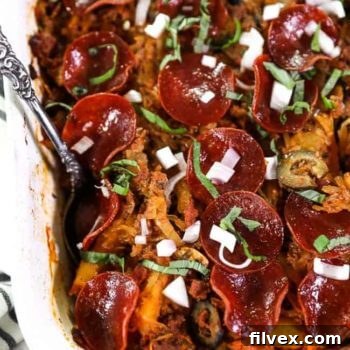 Close up overhead shot of spaghetti pizza casserole in casserole dish.