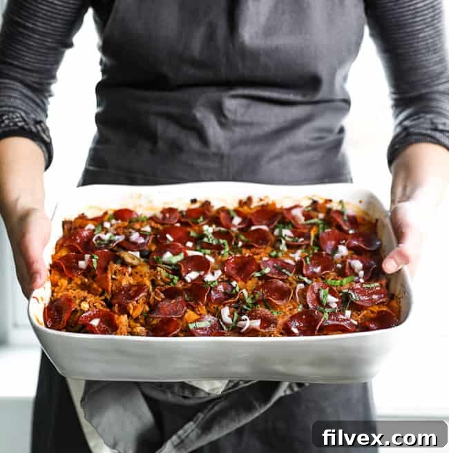 Holding casserole dish as if about to set spaghetti pizza casserole on the table. 