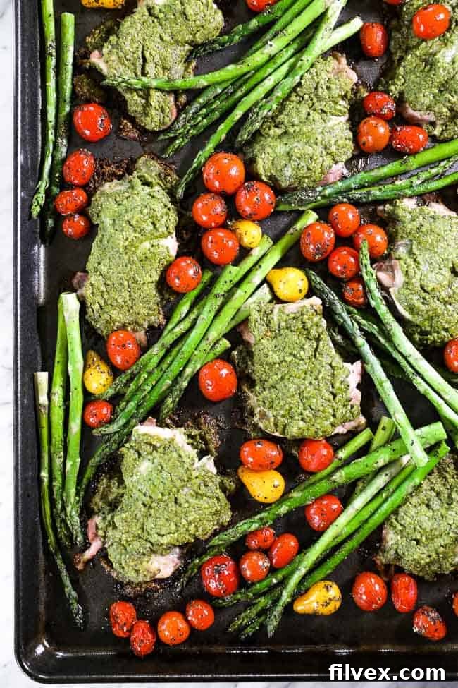 Easy baked pesto chicken on sheet pan with tomatoes and asparagus 