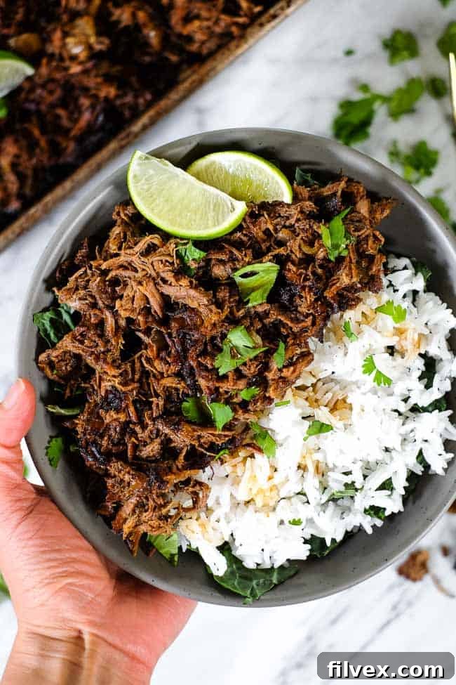 Beef Barbacoa served in a bowl with fresh toppings.