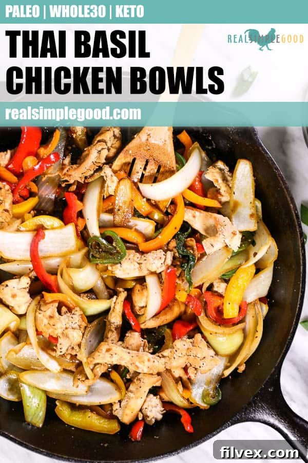 Close up of Thai basil chicken in a cast iron skillet with serving spoon. 