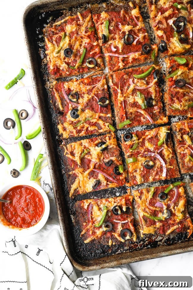 Keto meatza on a sheet pan cut into square slices. 