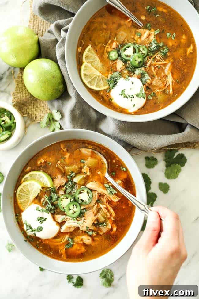 Instant Pot White Chicken Chili in a bowl with various toppings, close-up with a spoon.