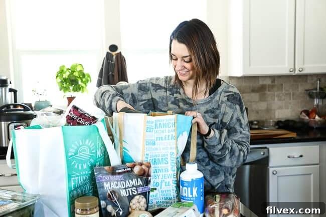 Person unloading grocery bags in kitchen