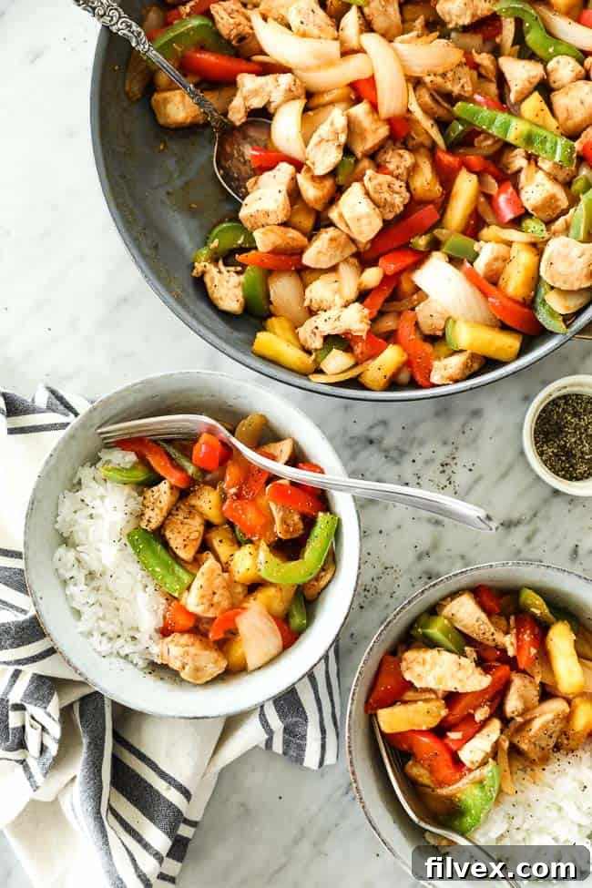 Overhead shot of sweet and sour chicken in skillet with serving spoon and served up in two bowls with white rice. 
