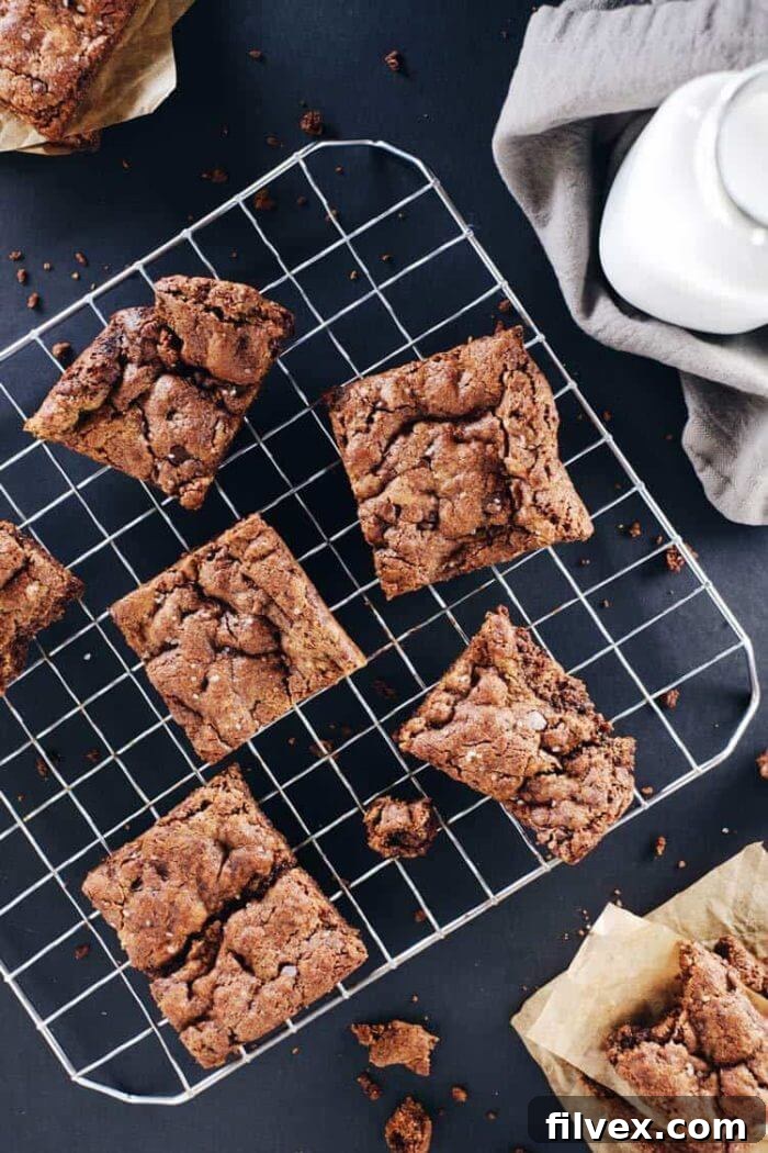 A tempting image of paleo chocolate chip fudge brownies, sliced and stacked to show their dense, fudgy interior packed with chocolate chips. This healthy version promises all the classic brownie satisfaction.
