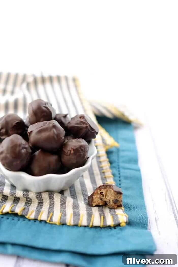 A delightful image of chocolate chip cookie dough bites, perfectly portioned and ready to enjoy. The visible chocolate chips and soft texture convey a comforting, nostalgic treat, made healthy.