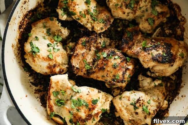 Close up image of succulent lemongrass chicken thighs in a sizzling skillet, garnished with fresh cilantro.