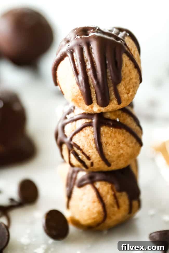 Three perfectly stacked no-bake peanut butter balls, showcasing their smooth, creamy texture and ready-to-eat appeal. These energy bites are a quick, healthy snack for any time of day.