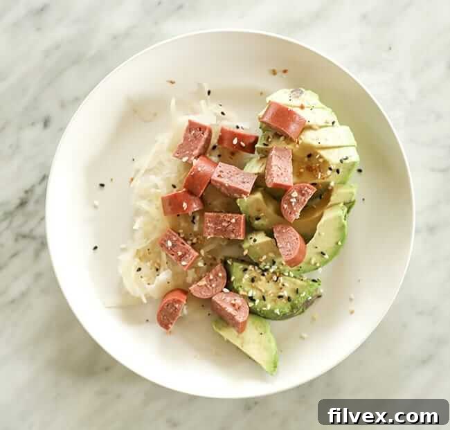 Sauerkraut, avocado and sliced hot dog on a plate