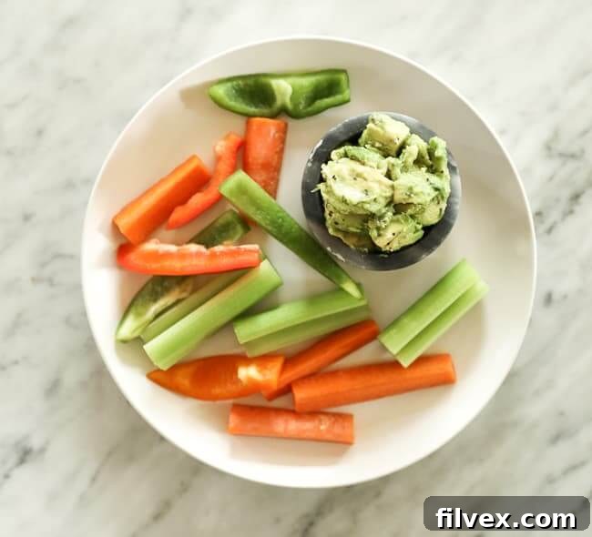 Sliced carrots and bell pepper on a plate with guacamole