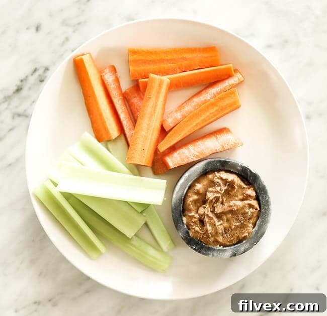 Sliced carrots and celery on a plate with almond butter