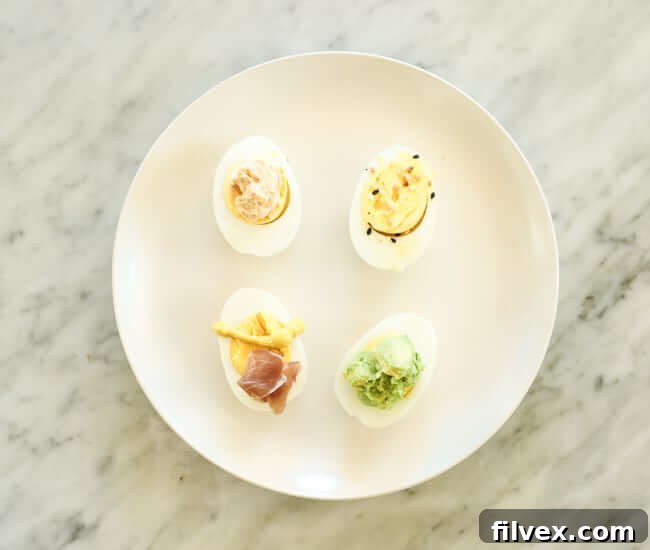 Hard boiled eggs cut in half with various toppings on a plate