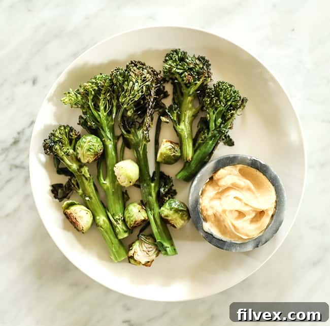 Roasted broccolini and brussels sprouts on a plate with mayo