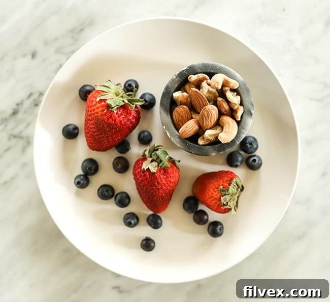 Strawberries and blueberries on a plate with mixed nuts