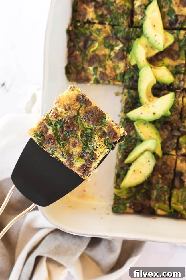 Slice of keto breakfast casserole on a spatula with sliced casserole underneath