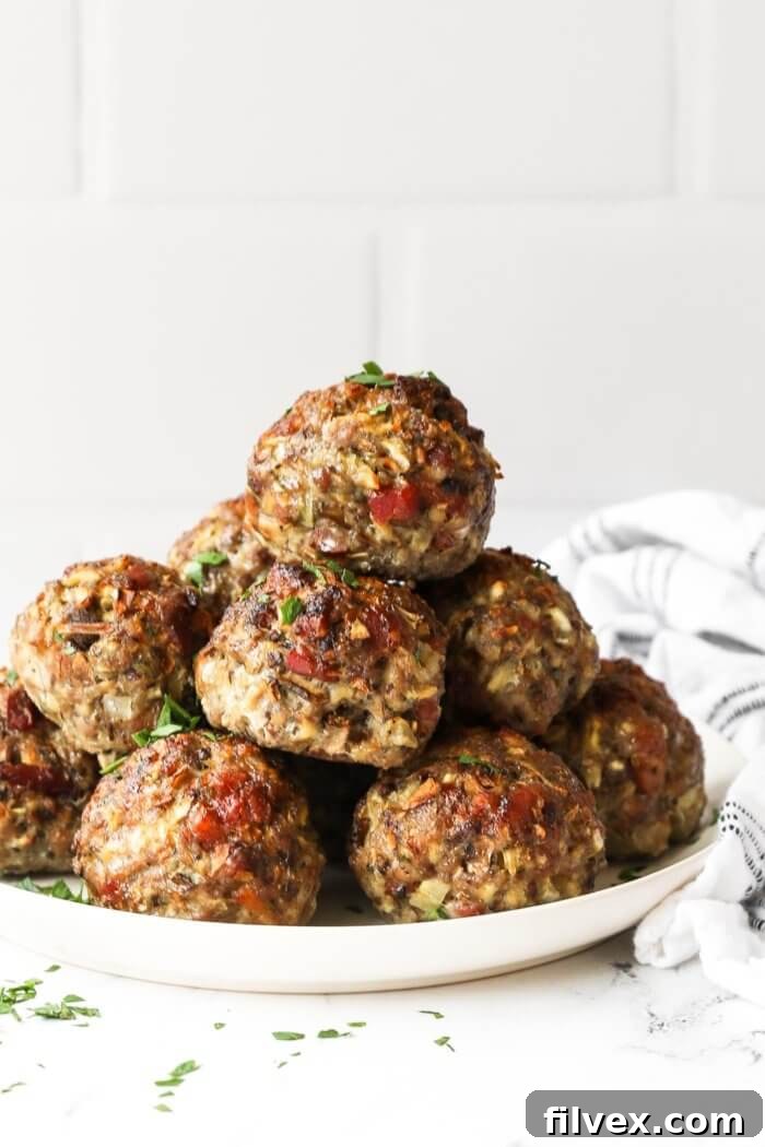 Breakfast sausage meatballs stacked up on a plate. Golden brown and perfectly cooked.