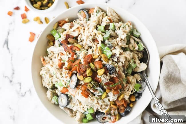 Overhead horizontal image of keto chicken salad in a bowl with a spoon, highlighting its freshness and appeal.