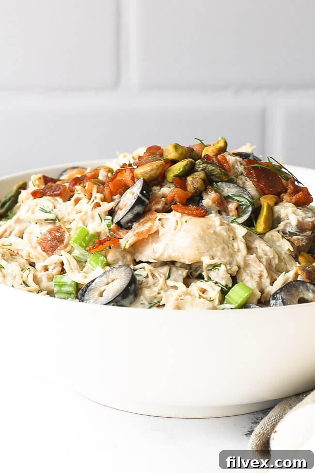 Angled vertical close up of keto chicken salad in a bowl, showing the creamy texture and diced ingredients.