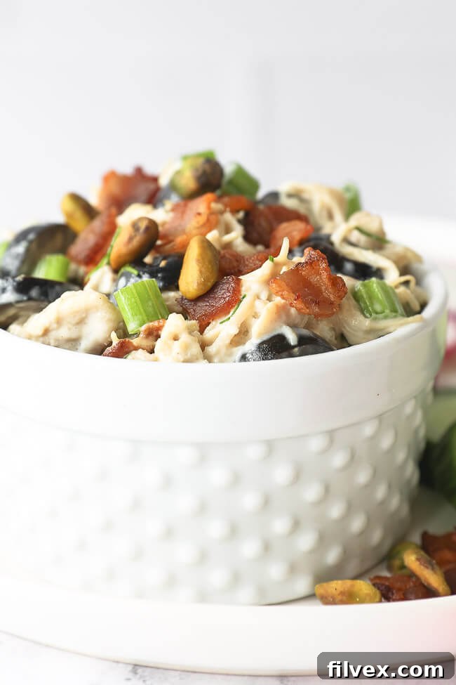 Vertical angled close up of chicken salad in a ramekin, showing its serving potential.