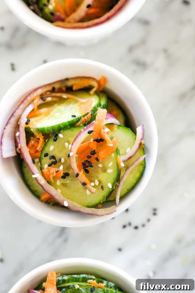 Close up of asian cucumber salad in a ramekin with sesame seeds on top