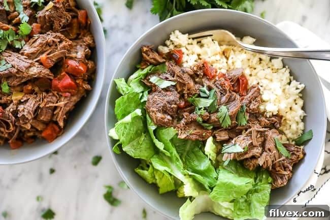 Mexican shredded beef in bowl with cauliflower rice and chopped lettuce