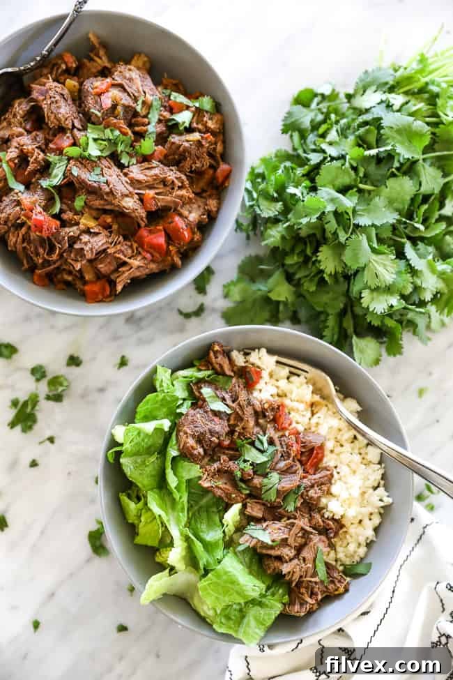 Mexican shredded beef in bowl with cauliflower rice, chopped lettuce and fork