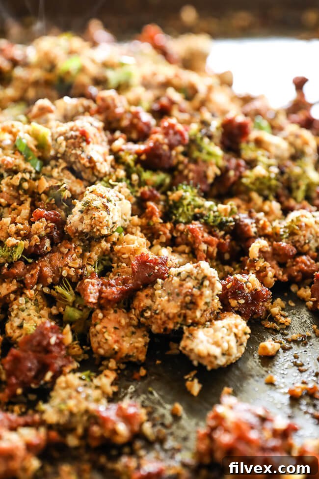 Easy chicken and chorizo bake piled up on a sheet pan vertical close up shot at angle