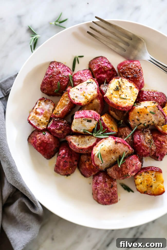 Roasted radishes on a plate with fork topped with rosemary vertical image