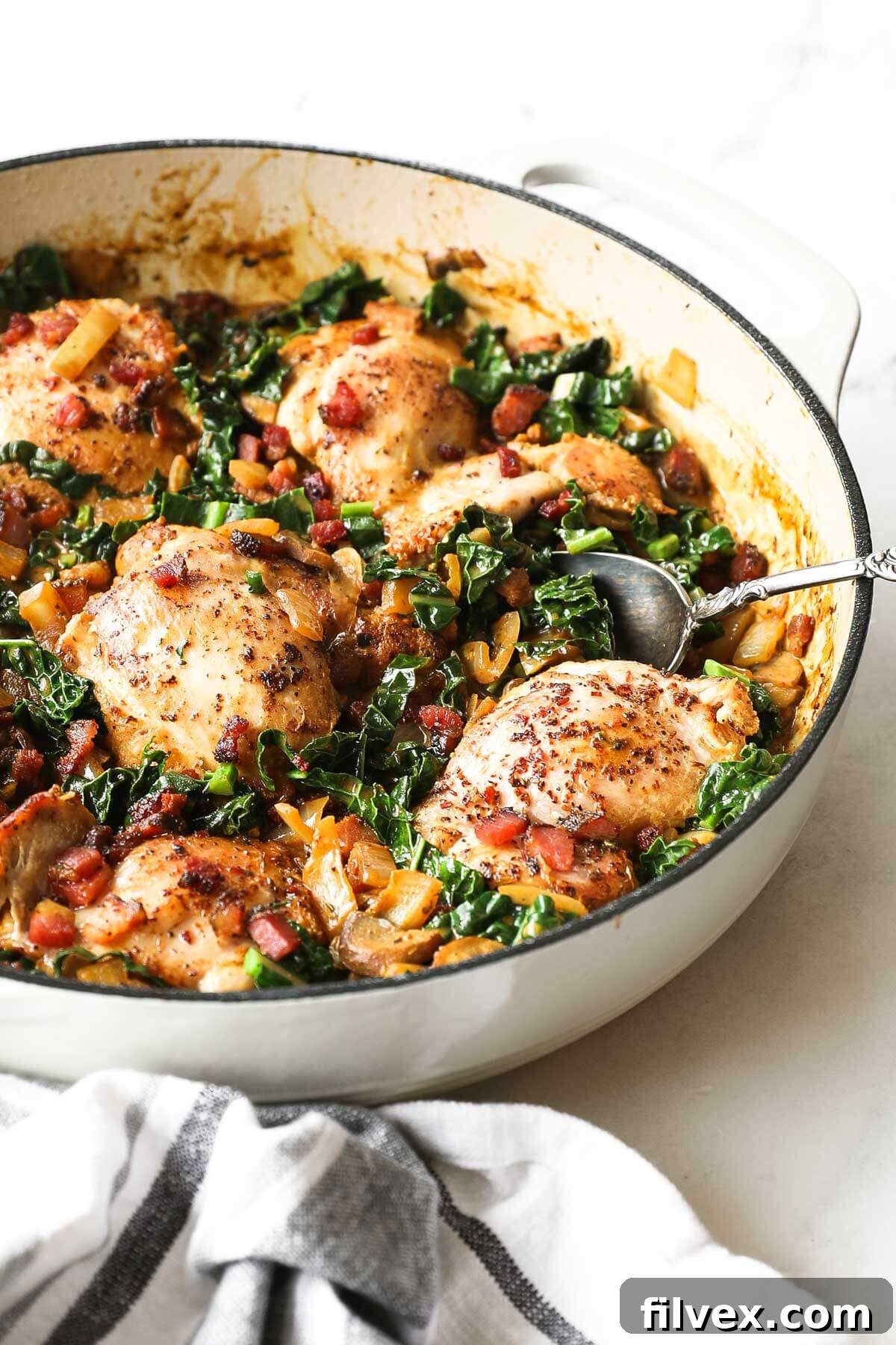 A serving of creamy mustard chicken with kale and mushrooms in a bowl.