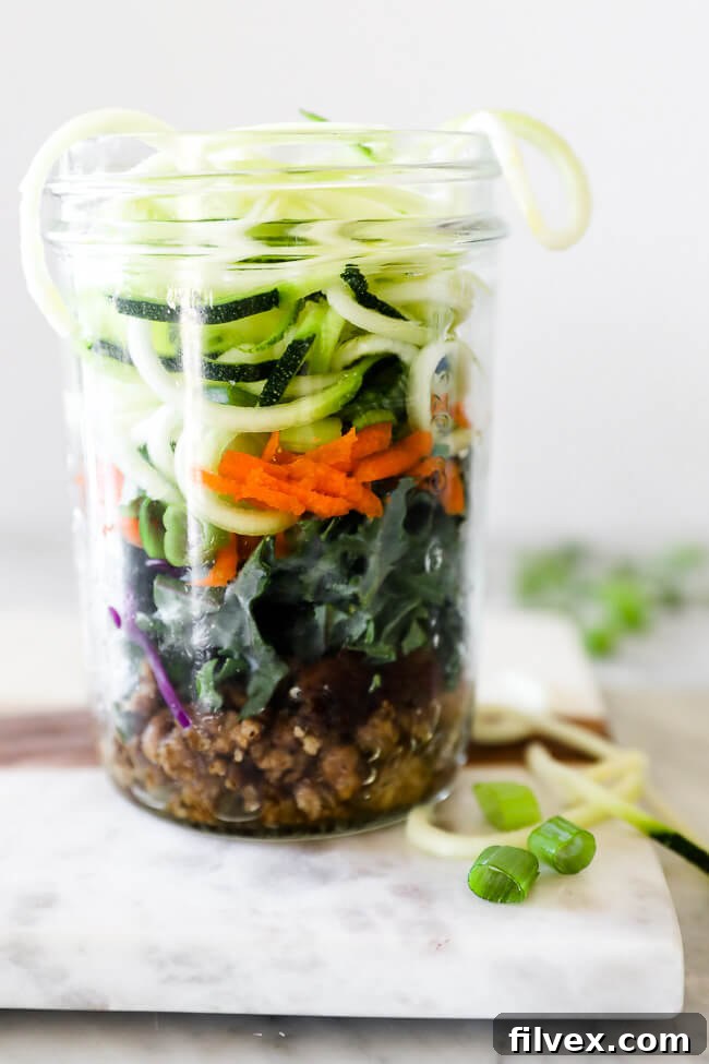 Vertical straight on shot of healthy ramen noodles layered in a mason jar.
