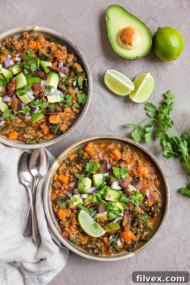 Bacon sweet potato chili in 2 bowls with various toppings, seen from an overhead perspective.