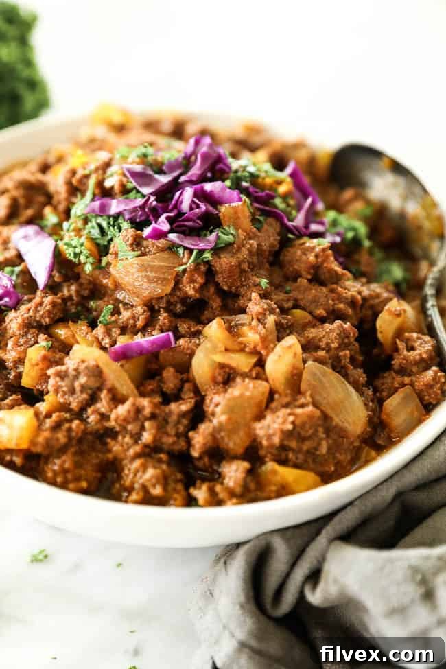 Sloppy joes in a bowl with a spoon and chopped purple cabbage topping, ready to be enjoyed.
