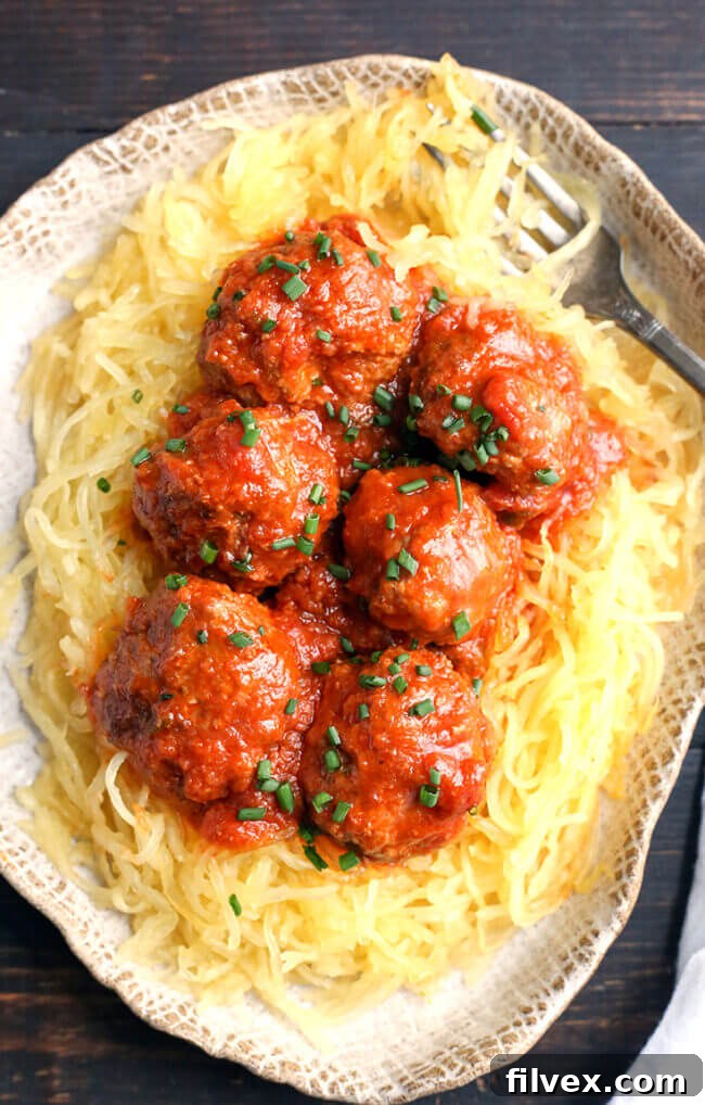Plate of meatballs and red sauce over spaghetti squash, a classic and healthy combination.