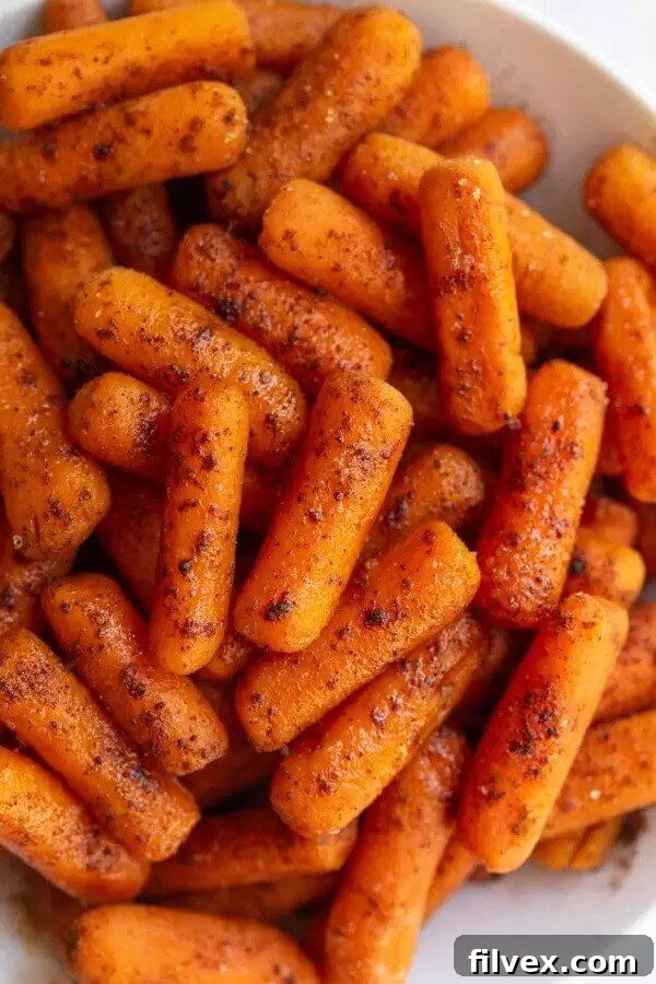 Plate of baby carrots with maple cinnamon topping, a sweet and simple side.
