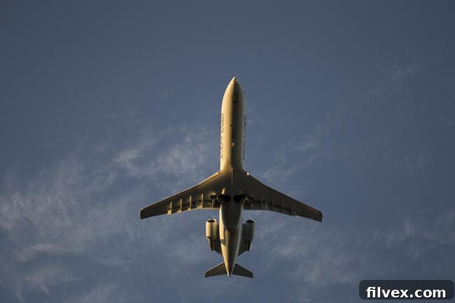 A stylized image of a plane flying through a clear blue sky, symbolizing breaking free from autopilot mode and taking control of one's life's direction.