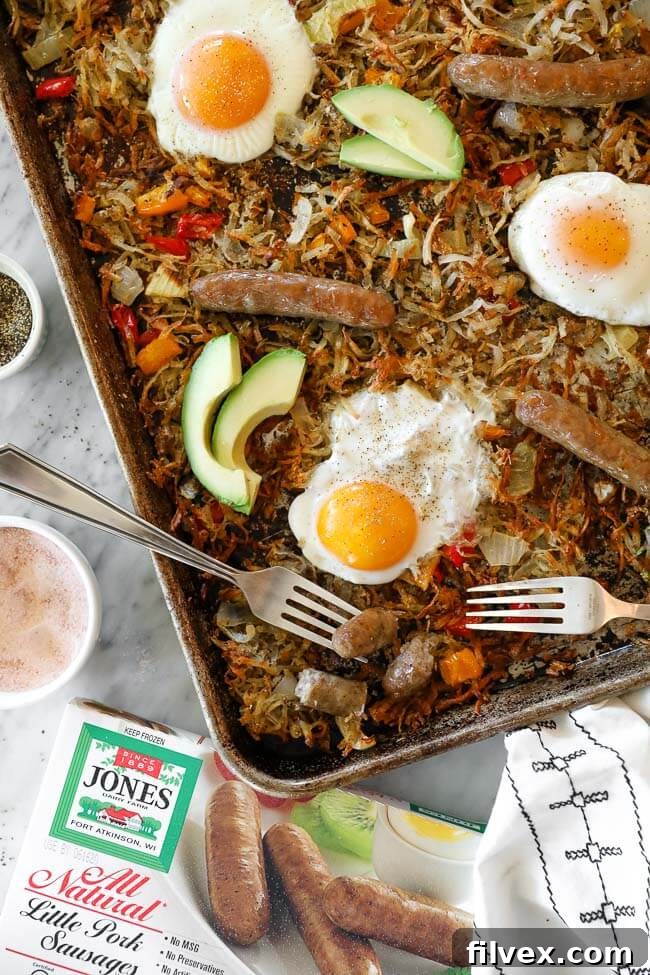 Overhead image of sheet pan breakfast bake on the pan with a sausage cut up and a bit on one fork. 