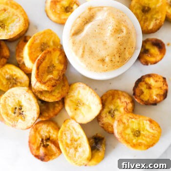 Close up vertical overhead image of pan fried plantains with dipping sauce.