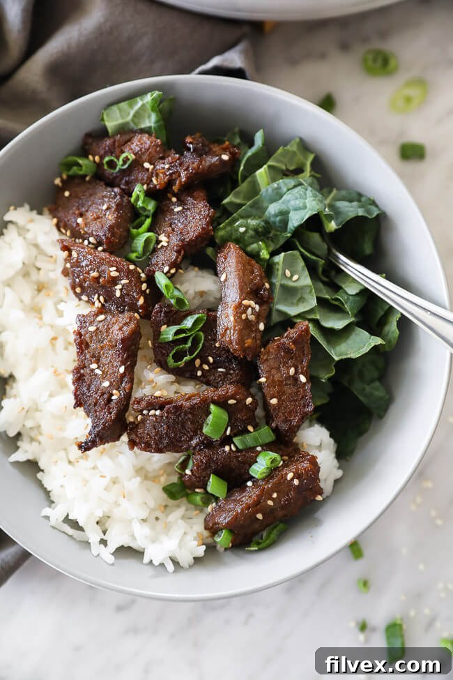 Close-up of Korean beef bulgogi in a bowl with kale and rice, highlighting the tender beef