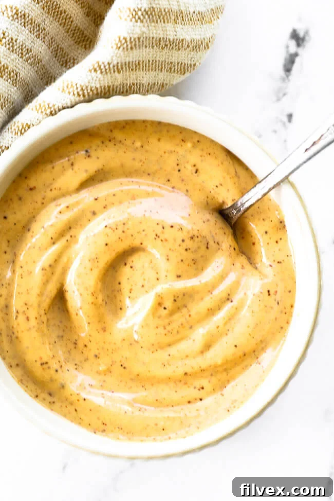 Creamy homemade chipotle aioli served in a small white ramekin, garnished with chili flakes, ready to be enjoyed.