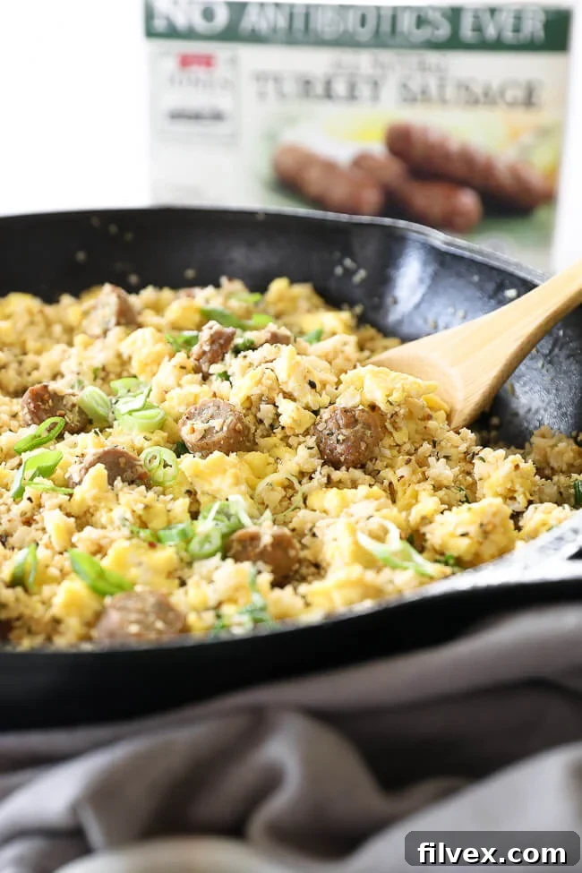 Angled image of breakfast fried rice in skillet with wooden spoon, showcasing crispy texture.
