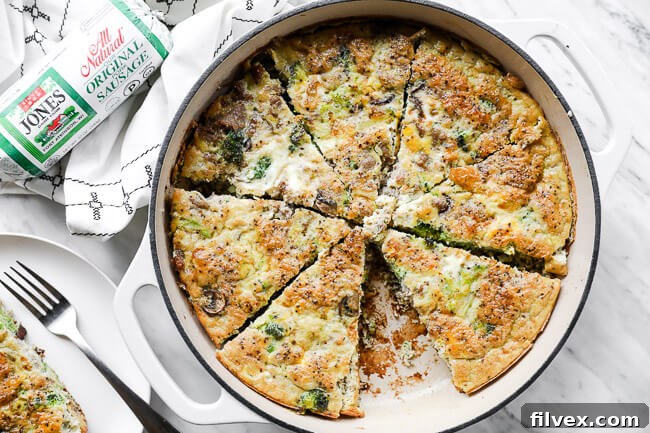 Horizontal overhead image of keto frittata in a large skillet, cut into slices like a pie with one piece removed from pan.