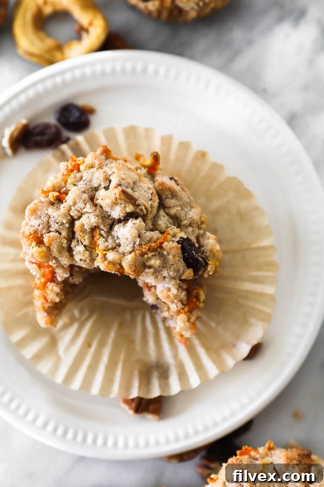 Close up overhead image of one breakfast muffin on a plate with a bite taken out. A delightful bite of a Morning Glory Muffin.